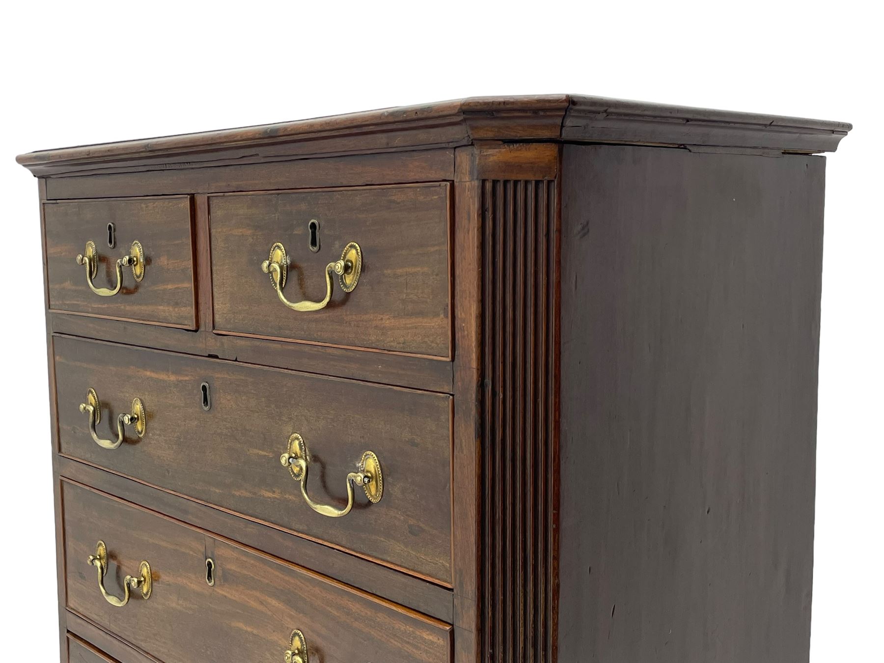 Small George III mahogany chest, rectangular canted form, moulded top over two short and three long cock-beaded drawers, fitted with brass swan neck handles and oval plates, enclosed by fluted upright corners, on bracket feet 