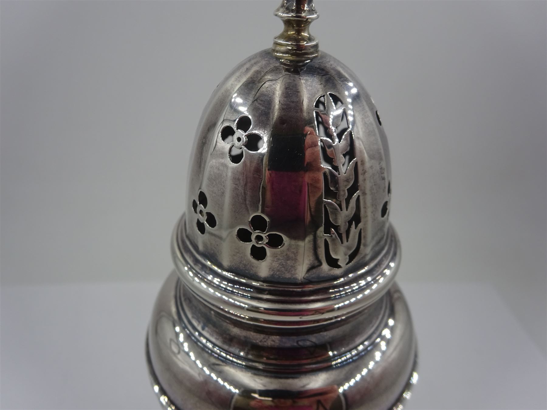 1920s silver sugar caster, of typical form with faceted body and pierced floral cover, upon stepped circular foot, hallmarked Adie Bros, Birmingham 1928, H20cm