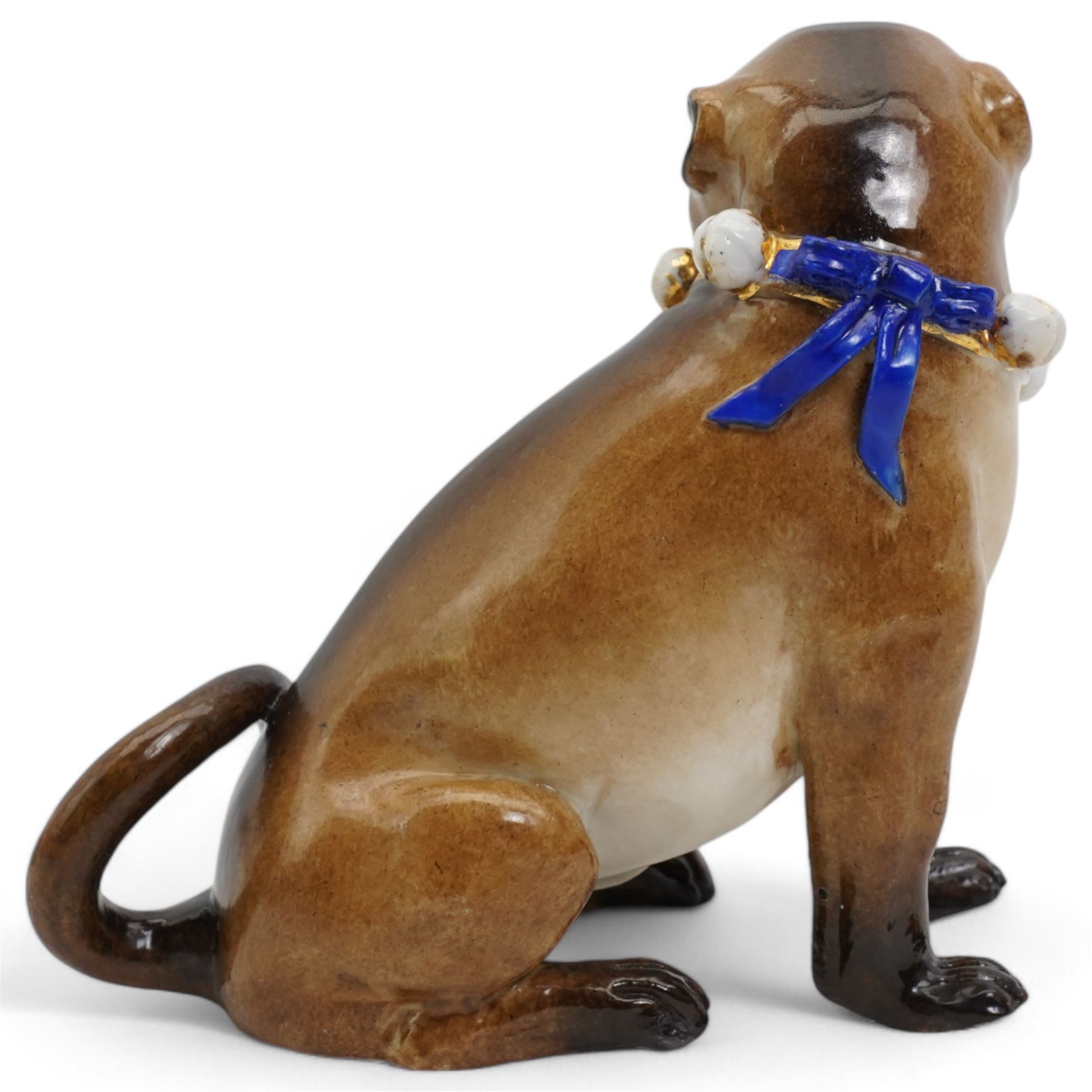 German porcelain model of a Pug, wearing a blue and gilt collar with bells, after J J Kändler, H12cm 