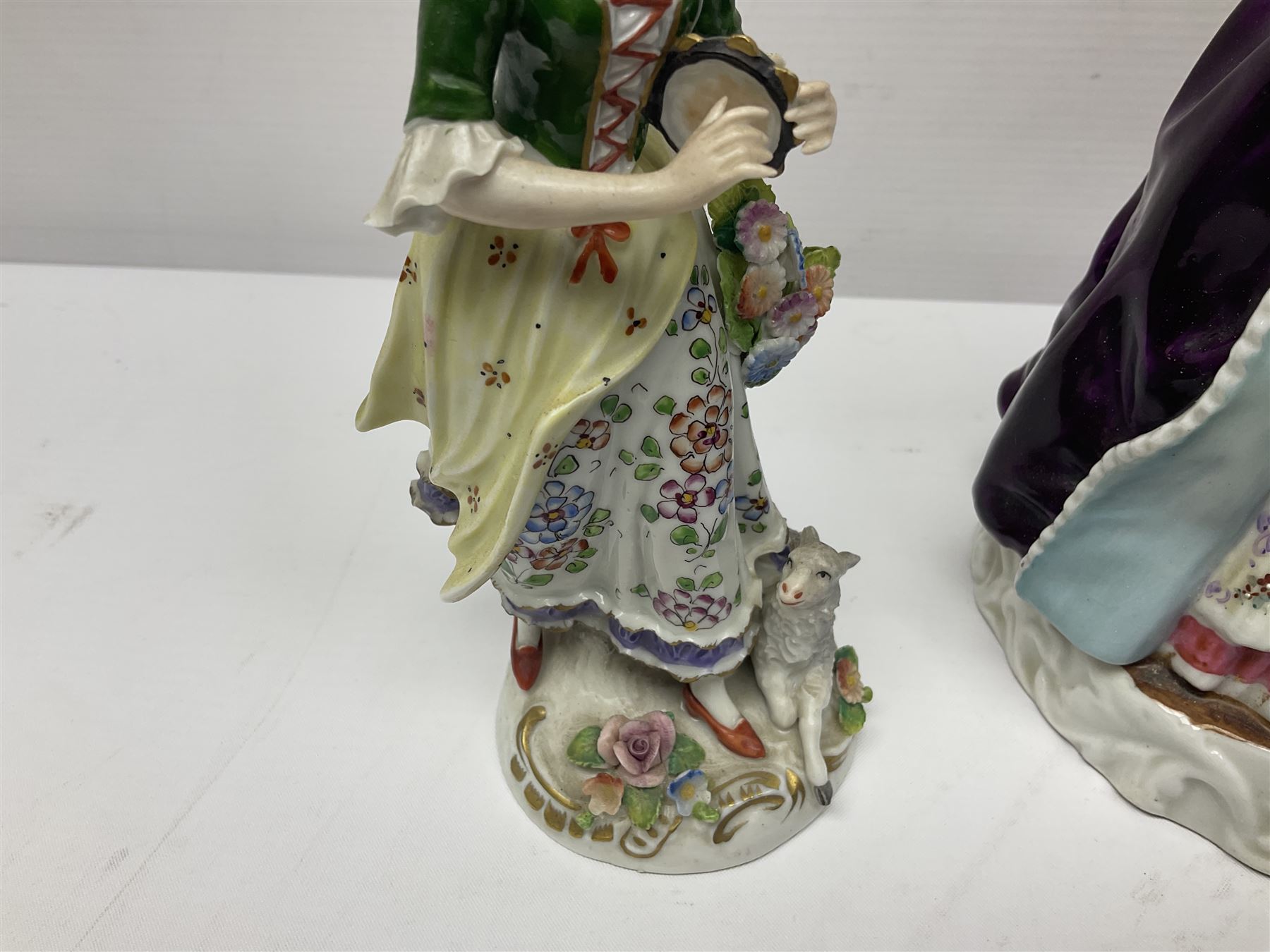 Continental figure modelled as a girl holding her lace skirt upon a circular base, together with two other figures, largest H22cm