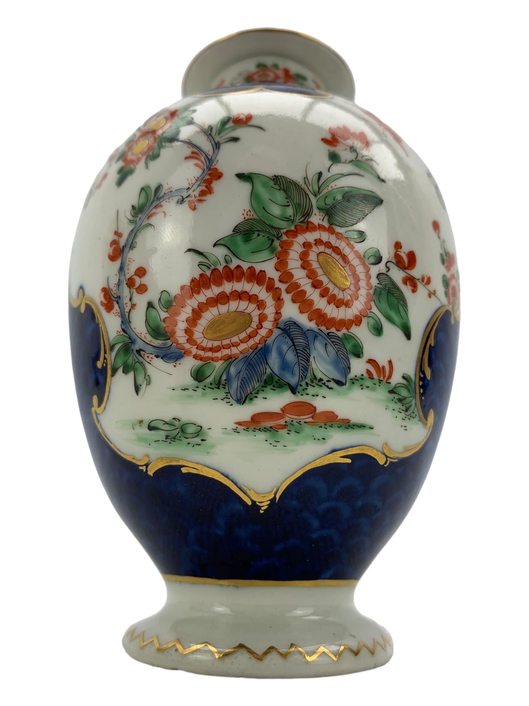 18th century Worcester tea caddy, of oval form and painted in the Kakiemon palette with reserves of flowers against a blue scale ground, H14cm together with a similar Worcester circular dish, painted with floral sprays, within a scalloped edge, blue crescent mark beneath, D19cm (2)