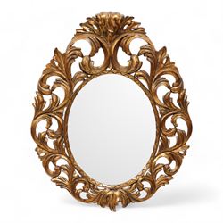 Florentine design gilt wall mirror, bevelled oval mirror plate surrounded by scrolling and interlaced acanthus leaves, curled leaf pediment 