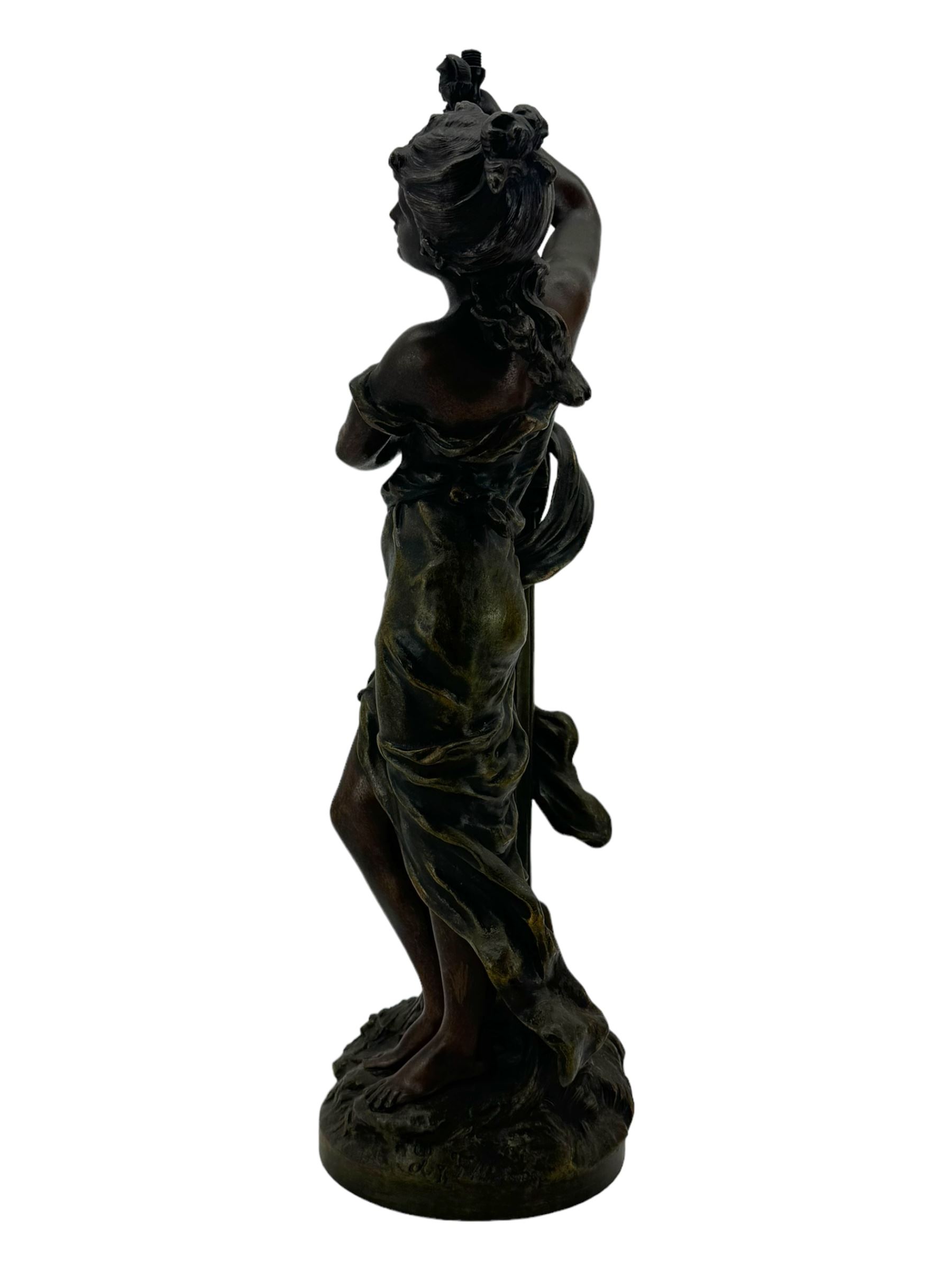 After L & F Moreau - Spelter table lamp in the form of a female figure next to a pedestal on circular naturalistic base H55cm