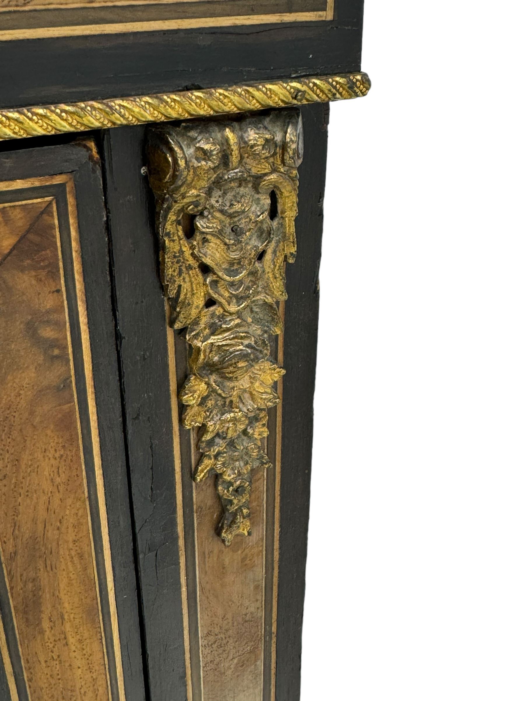 Victorian ebonised and walnut pier cabinet, rectangular top over figured frieze with central star motifs, enclosed by single glazed door, decorated with cast gilt metal mounts and beading, on chamfered plinth base 