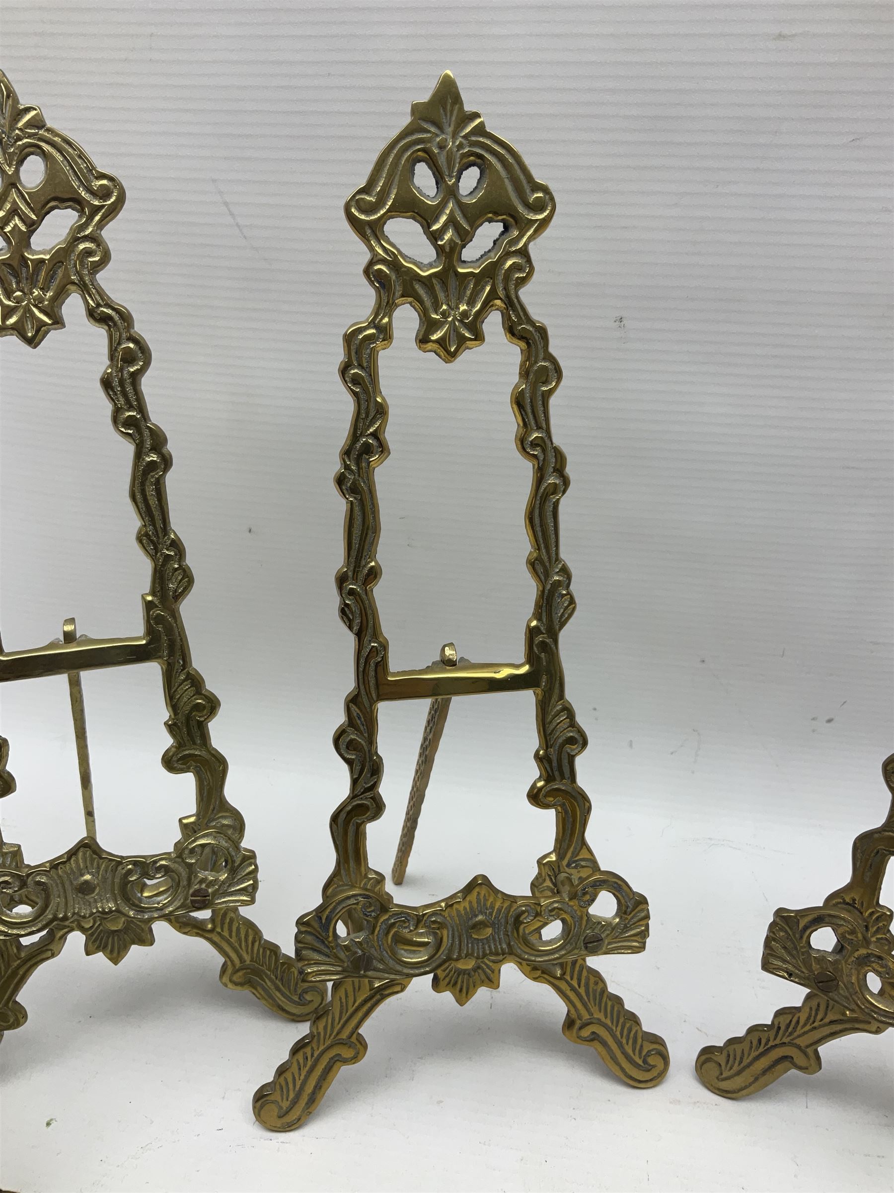 Set of six ornate cast brass easel stands, H30cm