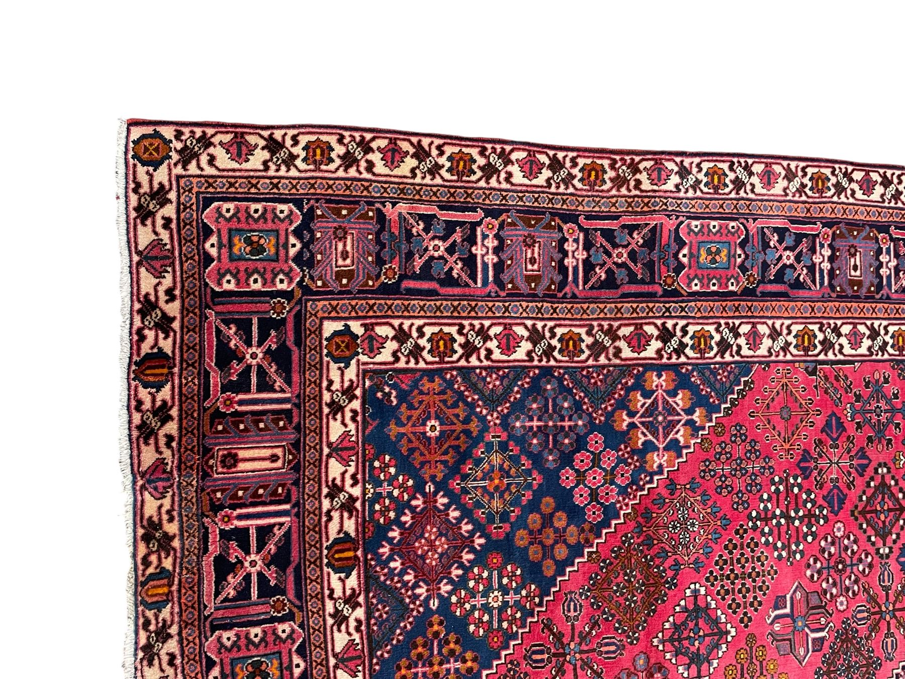 Persian Joshaghan red ground rug, the medallion, field and spandrels decorated with Pitrak and tree of life motifs, the border with repeating design decorated with stylised plant motifs, within guard stripes