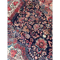 Persian Mahal indigo ground carpet, floral medallion on a field of swirling leafy branches and flower heads, shaped ivory field band decorated with flower head bouquets and trailing branches, the border decorated with floral motifs, within guard stripes