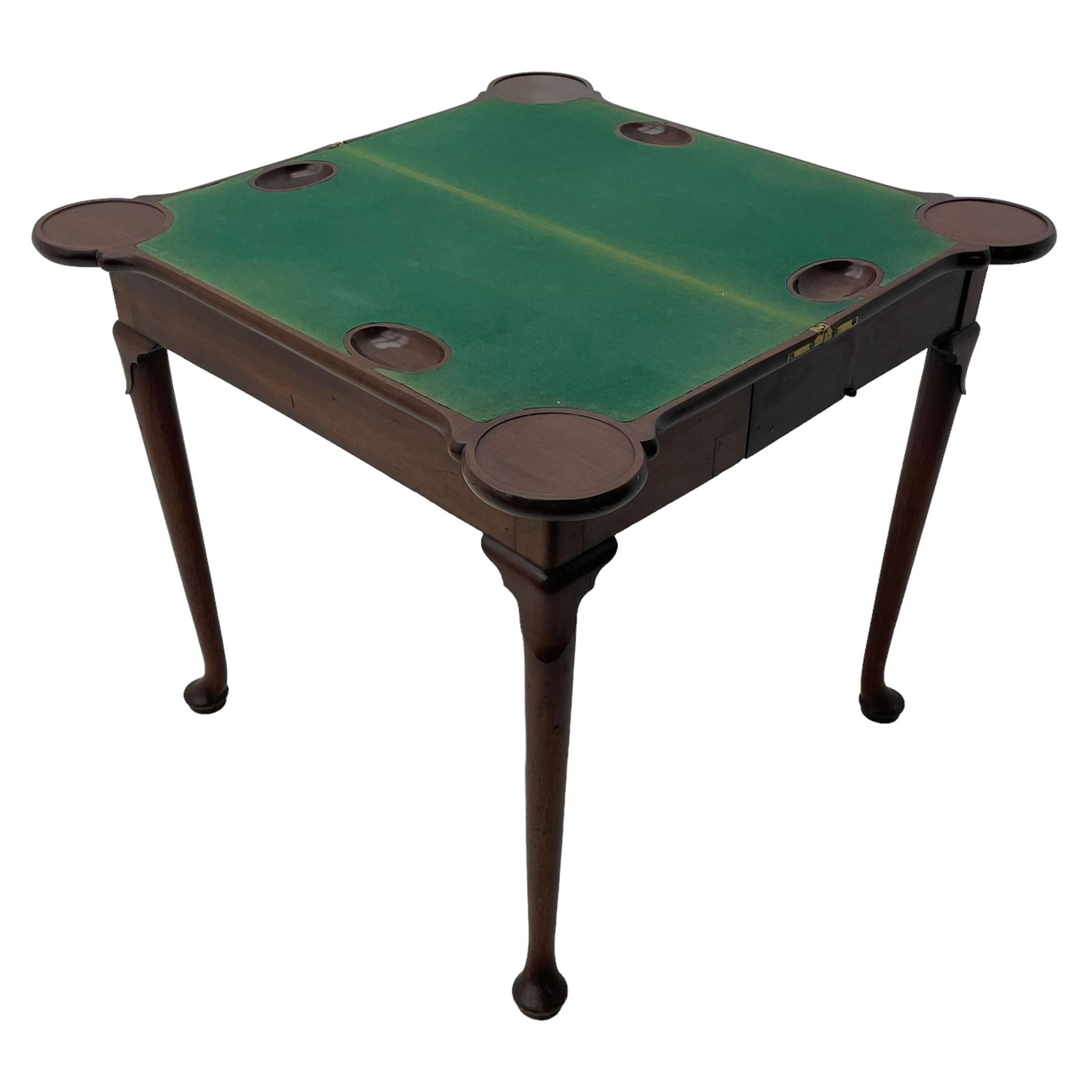 George III mahogany games table, the rectangular fold-over top with extending stepped rounded corners, opening to reveal baize lined interior with sunken counter wells, concertina action base, on lappet cabriole supports