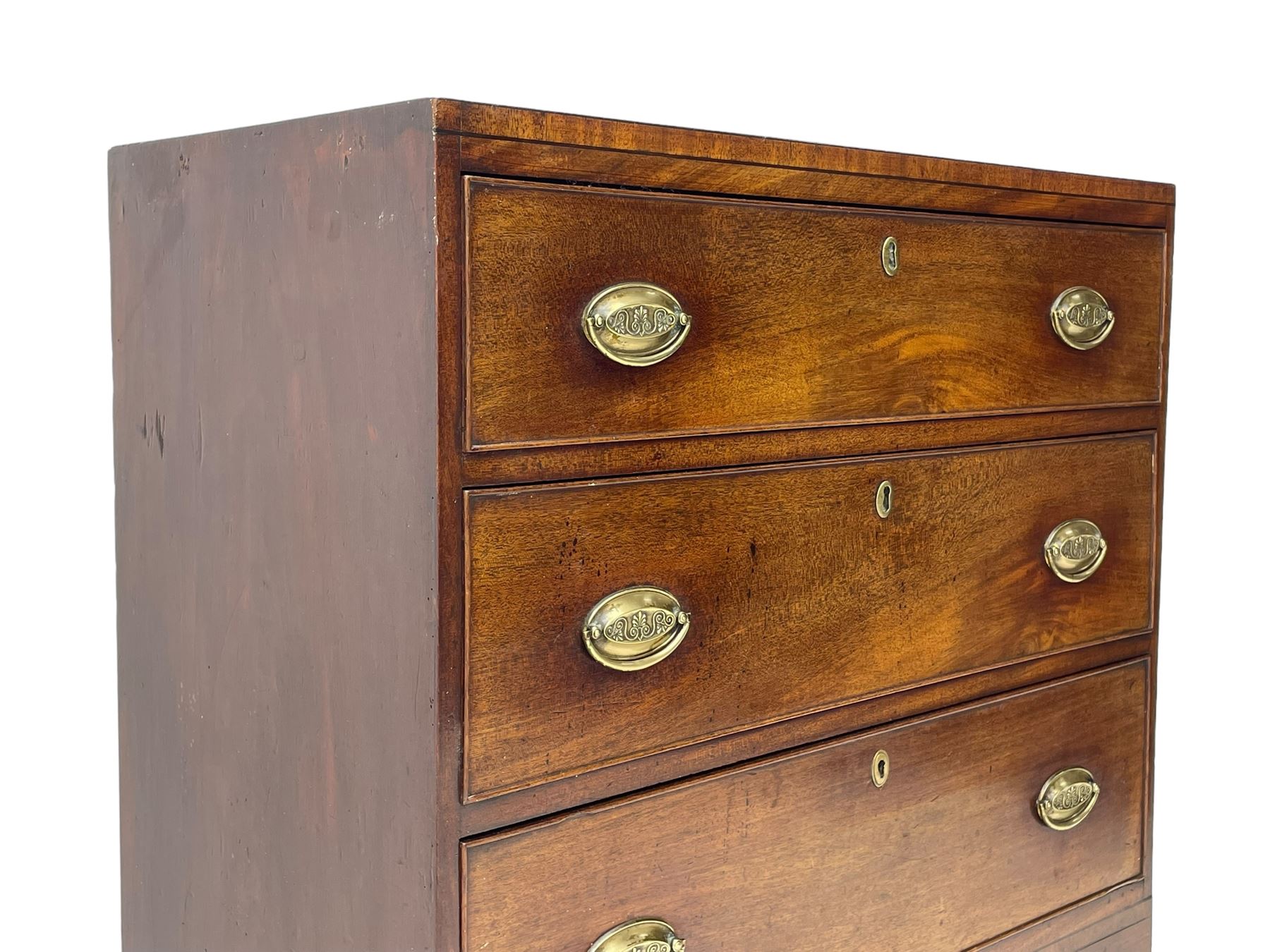 George III mahogany chest, rectangular ebony strung top, fitted with three graduating cock-beaded drawers with oval pressed brass handle plates and demi-lune handles, on tall bracket feet 