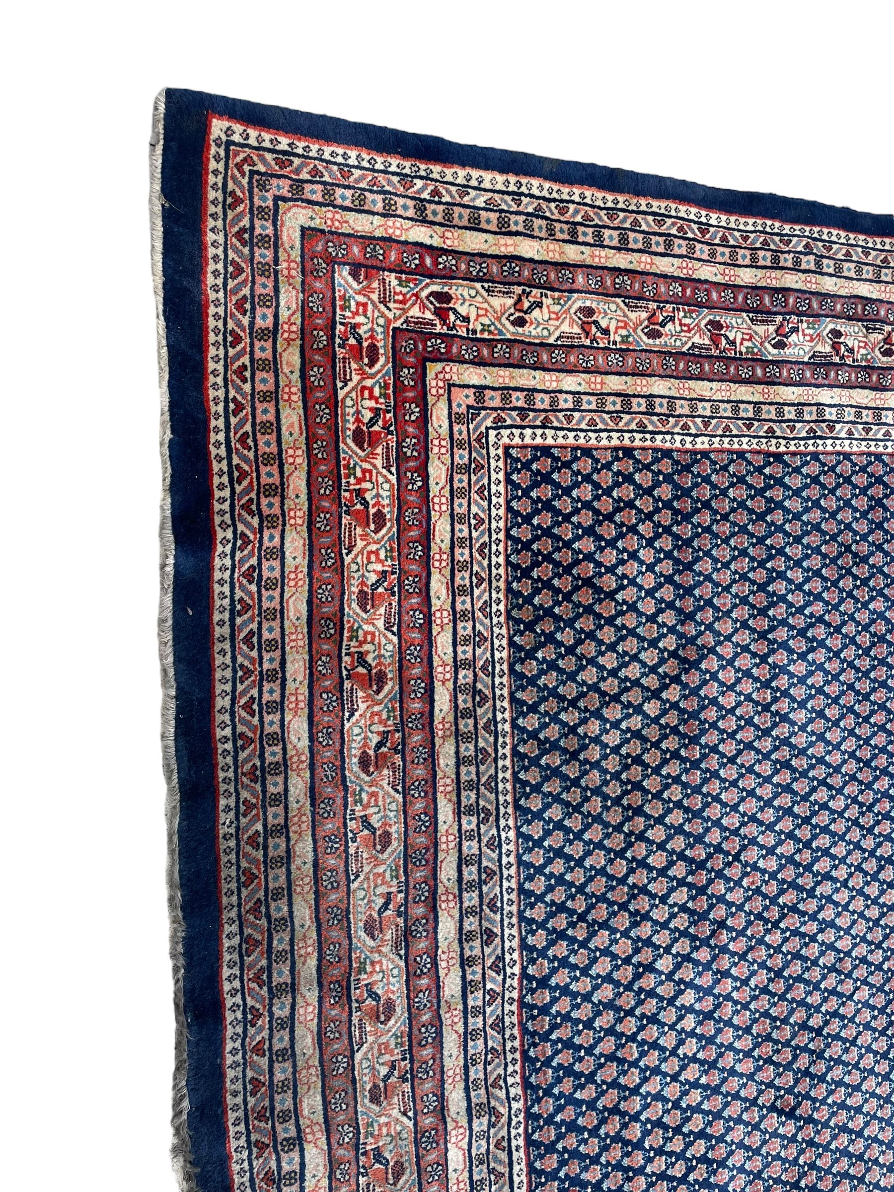 Large North-West Persian Arrak indigo ground carpet, the field decorated all-over with small Boteh motifs, multiple band border decorated with repeating geometric designs