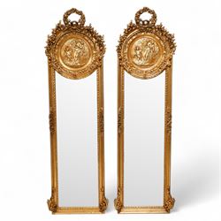 Pair of Victorian design gilt framed narrow wall mirrors, floral wreath pediment over ribb...