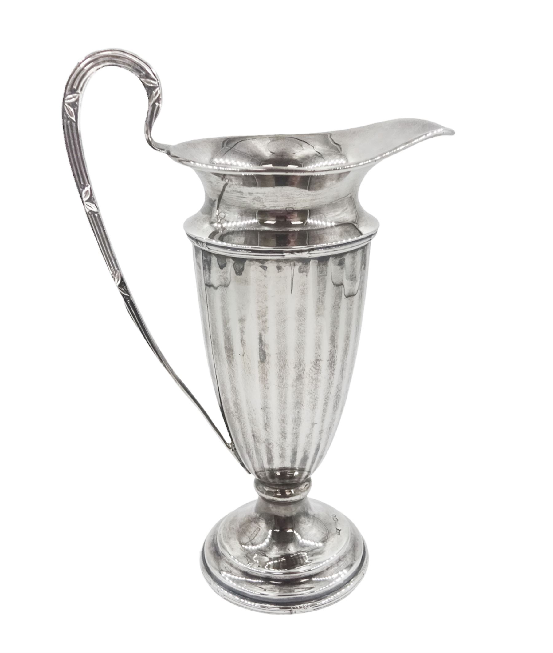 Early 20th century silver cream jug, of helmet form with faceted body and scroll handle, upon stepped circular foot, hallmarked Walker & Hall, date mark indistinct, H16.5cm