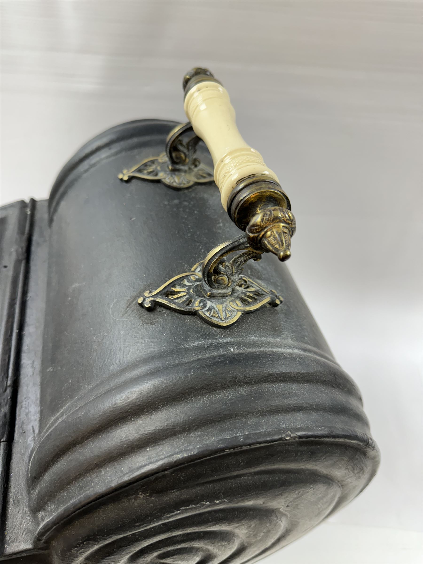 Victorian black matte metal coal scuttle, in the form of a nautilus shell, with ceramic wheels and handle, H47cm