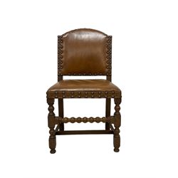 Set of six (4+2) early 20th century oak dining chairs, arched back and seat upholstered in tan leather with studwork detail, on turned supports united by bobbin-turned stretchers