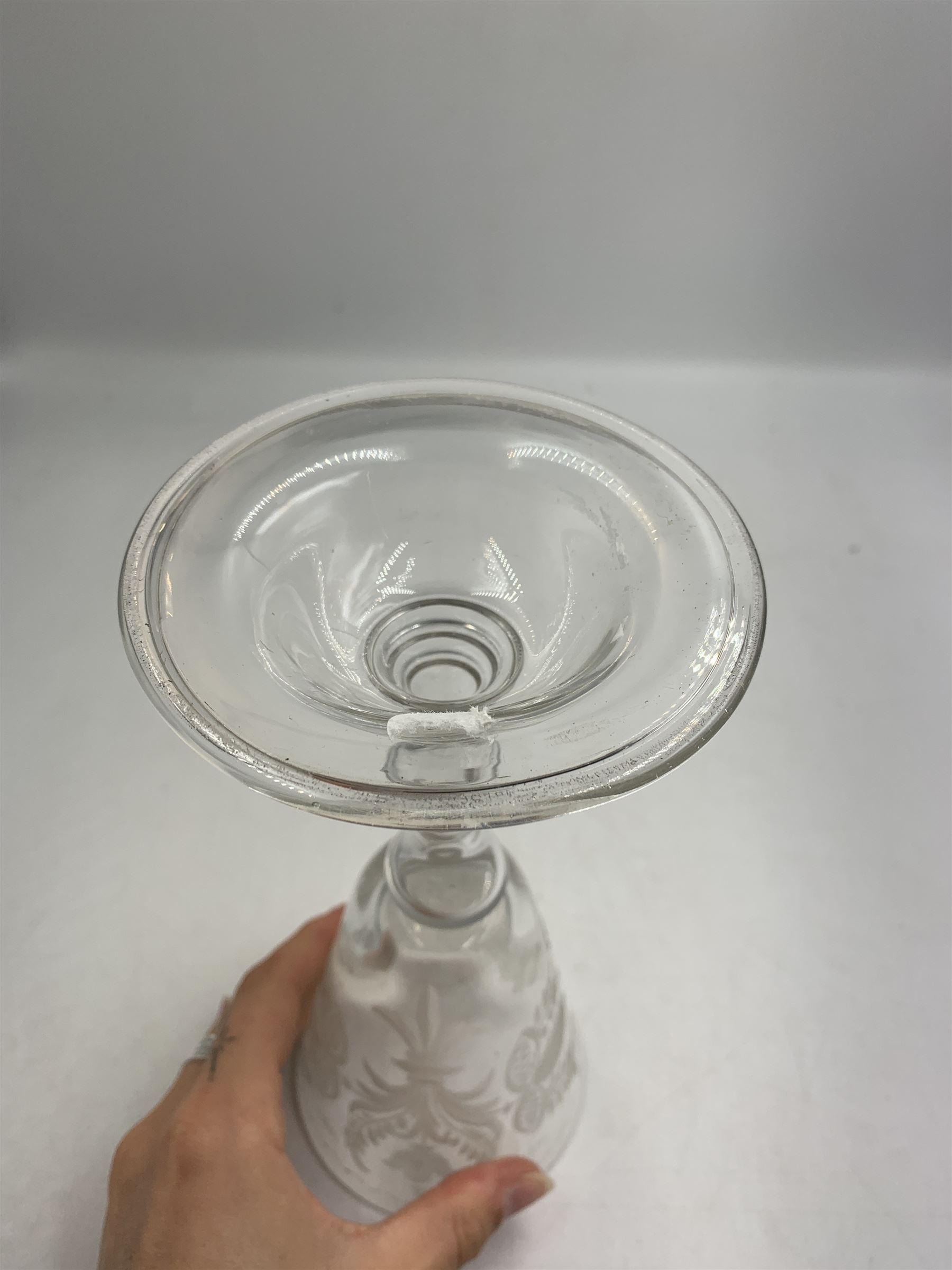 18th century large baluster wine glass, circa 1745, the funnel bowl decorated with a crest and foliate, to a knopped stem and deep domed  and upturned foot, H20cm