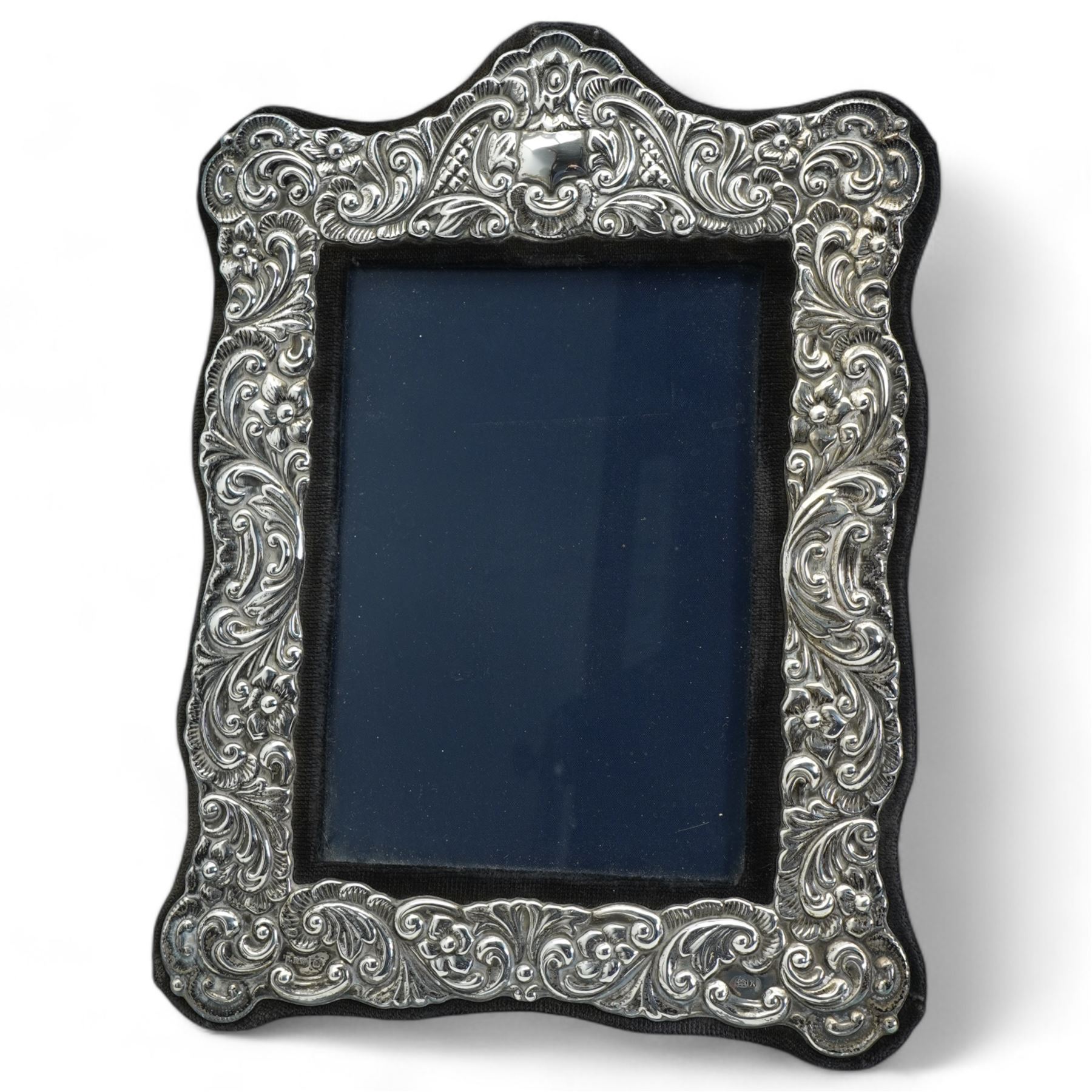 Embossed silver photograph frame, aperture 17cm x 12xm Sheffield 1984, Maker Laurence R Watson & Co  and an oval silver frame 13.5cm x 9.5cm  (2)