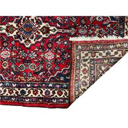 Persian Herati crimson ground rug, central ivory pole medallion surrounded by Herati motifs, with contrasting indigo spandrels, multi-band border with interlaced flowerheads