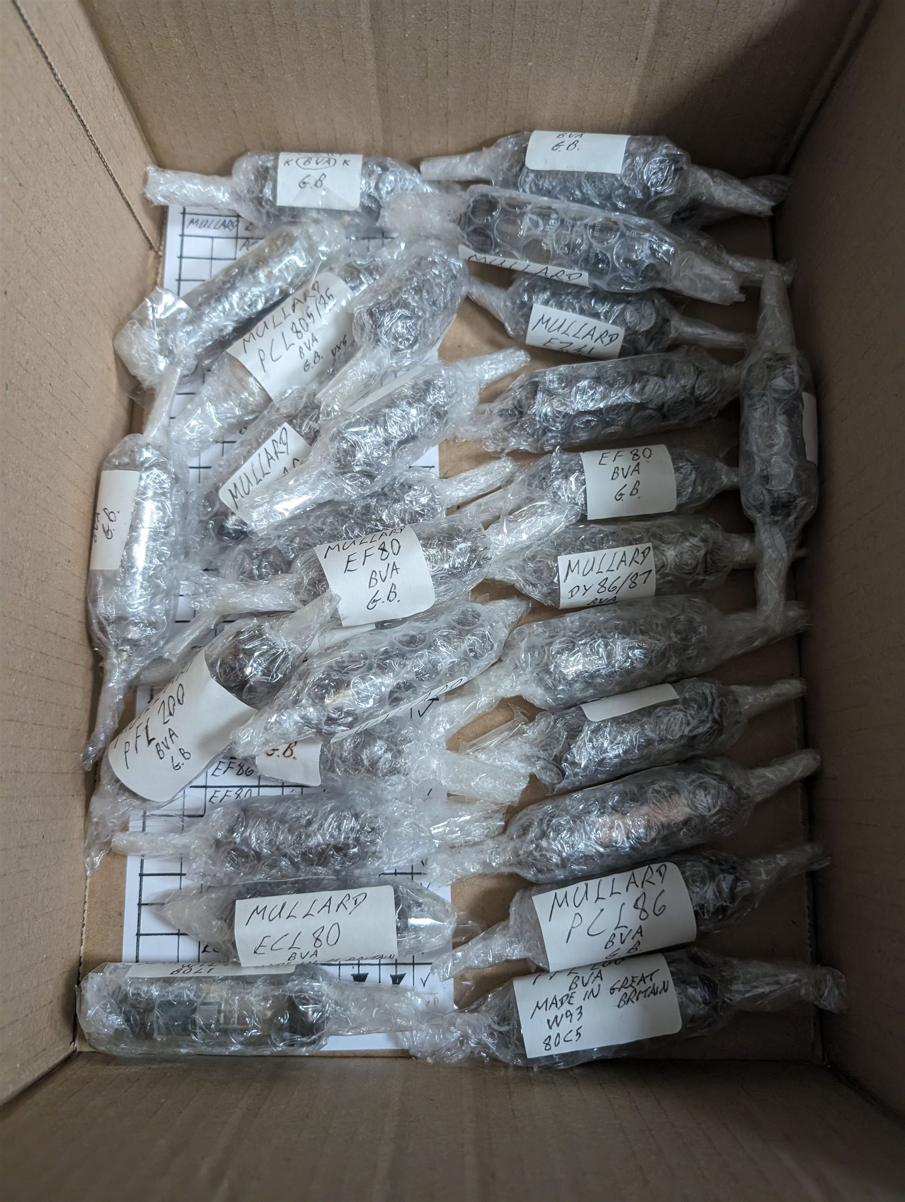 Collection of Mullard thermionic radio valves/vacuum tubes, mostly bubble wrapped and identified with lists