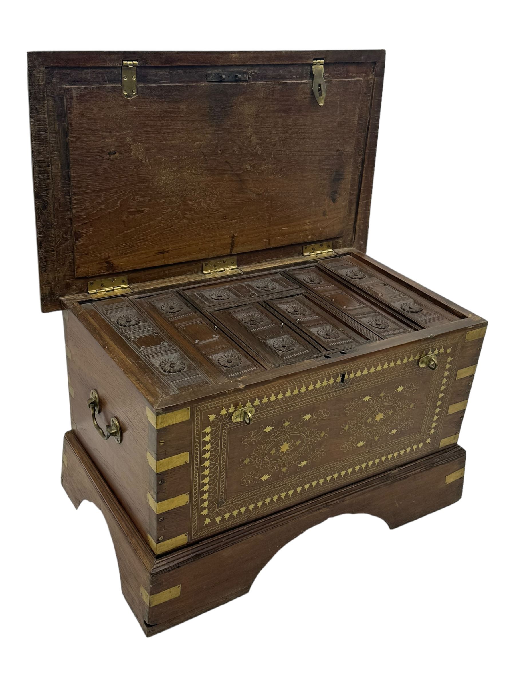 20th century mahogany chest, rectangular hinged top enclosing removable compartments with carved starburst motifs with linear and geometric patterns, brass inlay to the top and front, mounted corners and edges, on bracket base