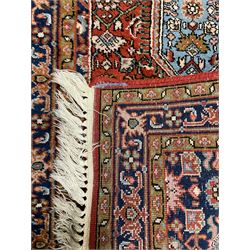 Small crimson ground rug, the extending lozenge field decorated with Herati motifs and flower heads, repeating guarded border