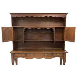 Early 20th century Georgian design oak dresser, projecting cornice with shaped apron over a three-tier plate rack with flanking fielded spice cupboards, the base fitted with three drawers, on turned supports