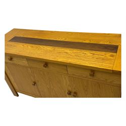 Contemporary oak sideboard, rectangular top with central contrasting plank, over three frieze drawers and three cupboards with enclosed shelving, on rectangular stile supports