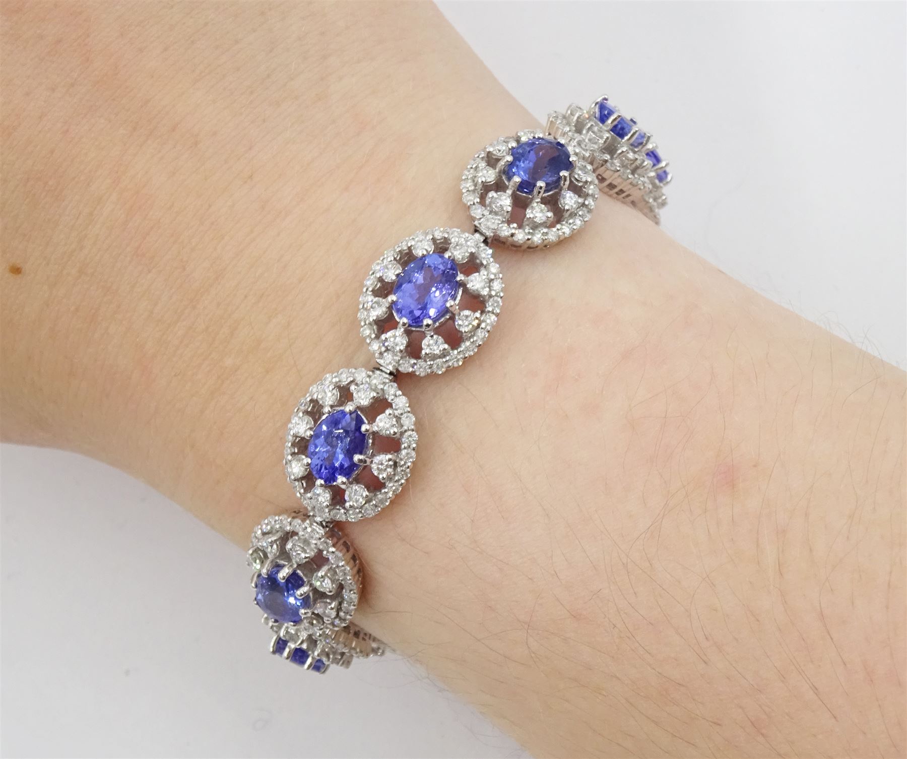 18ct white gold tanzanite and diamond bracelet, twelve oval link clusters set with oval cut tanzanite's and round brilliant cut diamonds, stamped 750, total tanzanite weight approx 11.00 carat, total diamond weight approx 3.65 carat