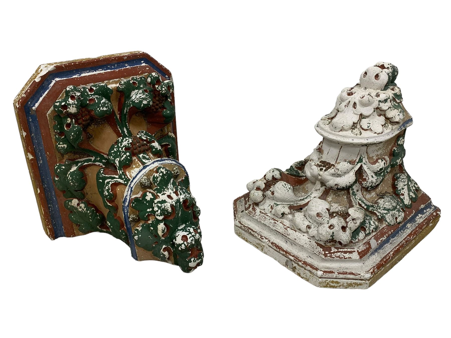 Two Victorian polychromed plaster cast corbels or wall brackets, canted rectangular tops over moulded edge and curled fruiting foliage