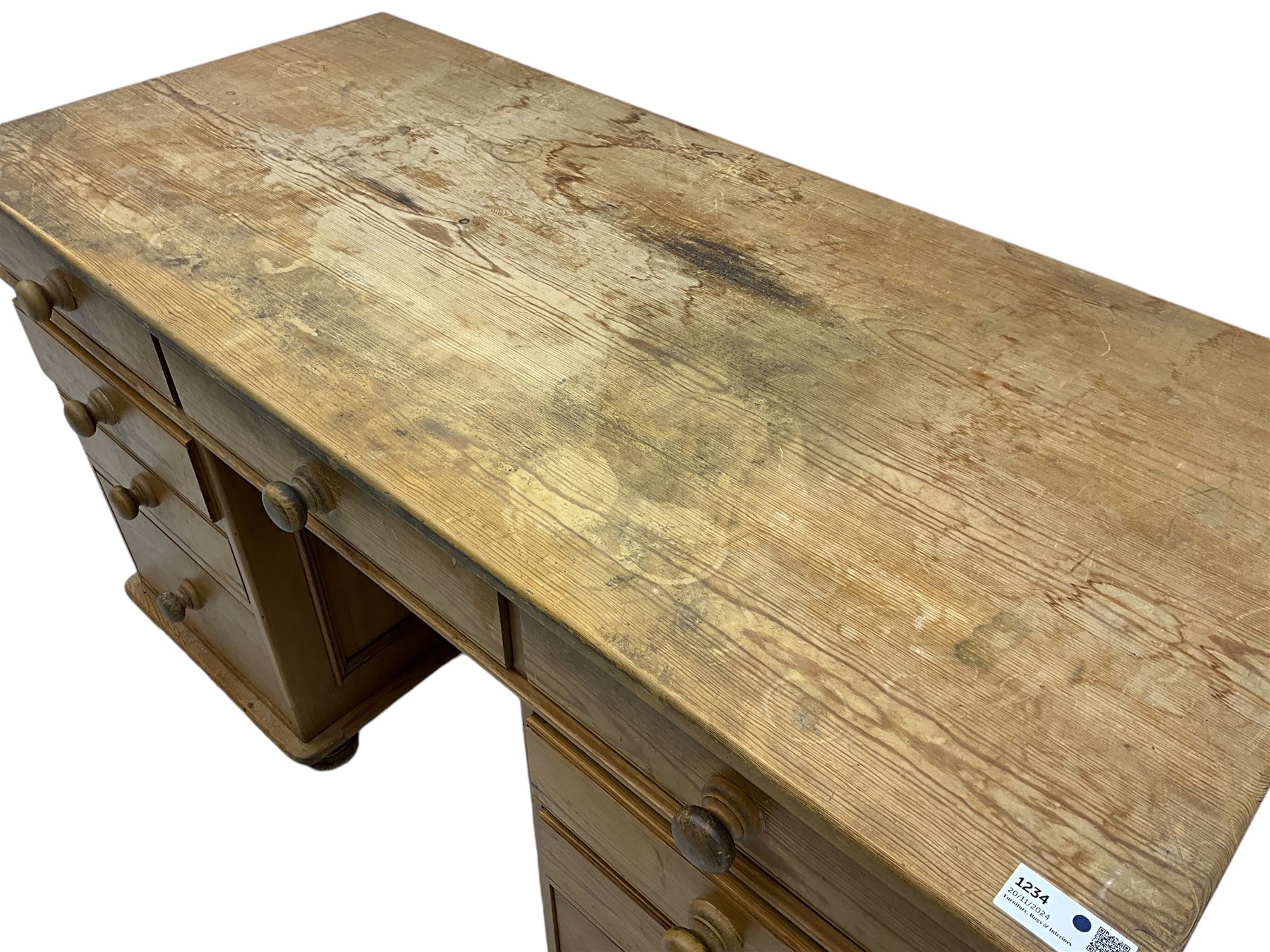 Waxed pine twin pedestal desk, rectangular top over nine drawers, on compressed bun feet 