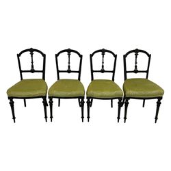 Set of four late Victorian ebonised dining chairs, decorated with carved and gilt foliate decoration, upholstered seats, on turned and fluted front supports 