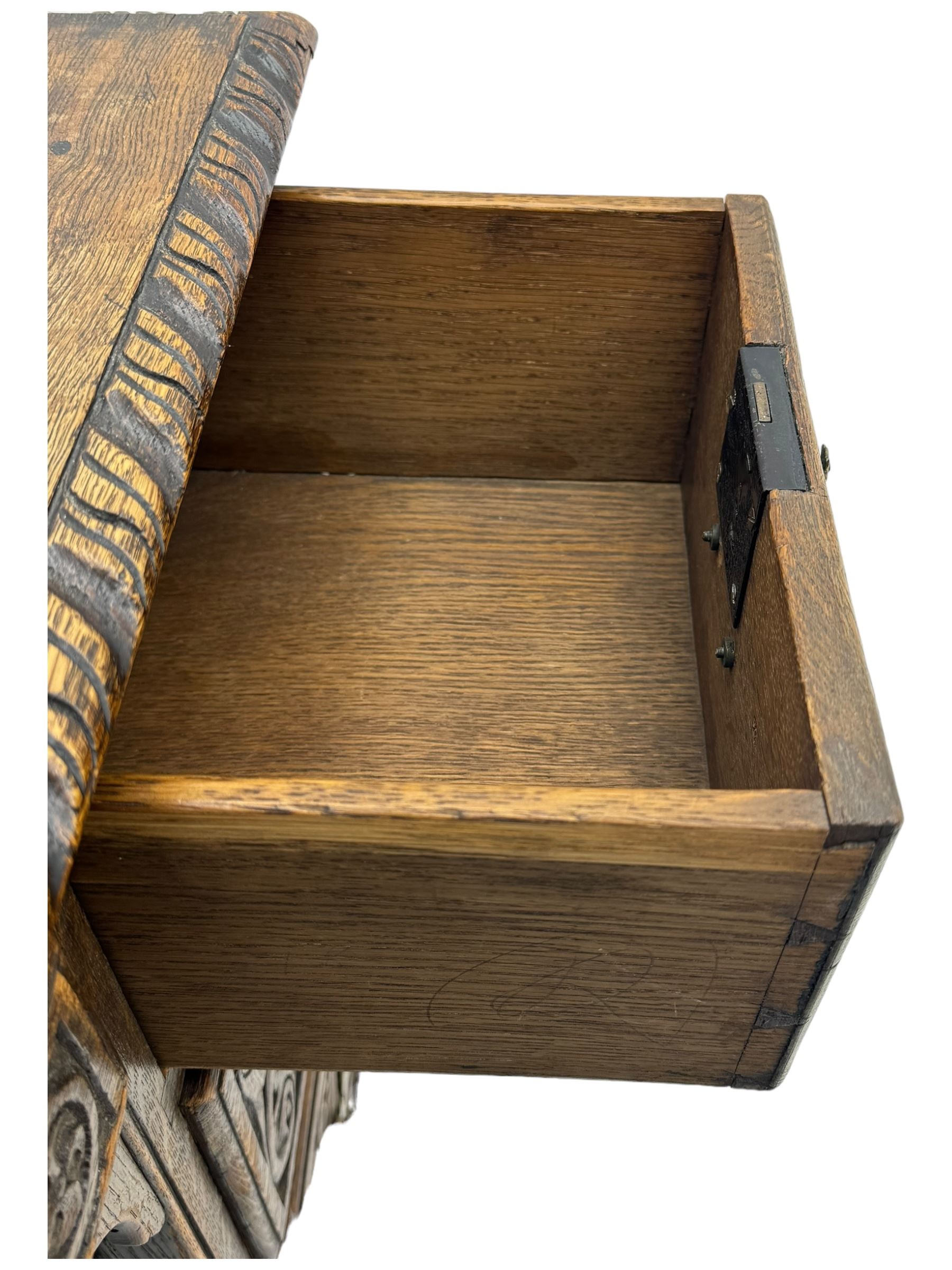 Victorian carved oak kneehole desk, the rectangular top with carved edge, above central drawer with carved front and brass handles, central kneehole with cupboard door, flanked by two banks of three graduating drawers each with similarly carved decoration, on shaped plinth base with castors