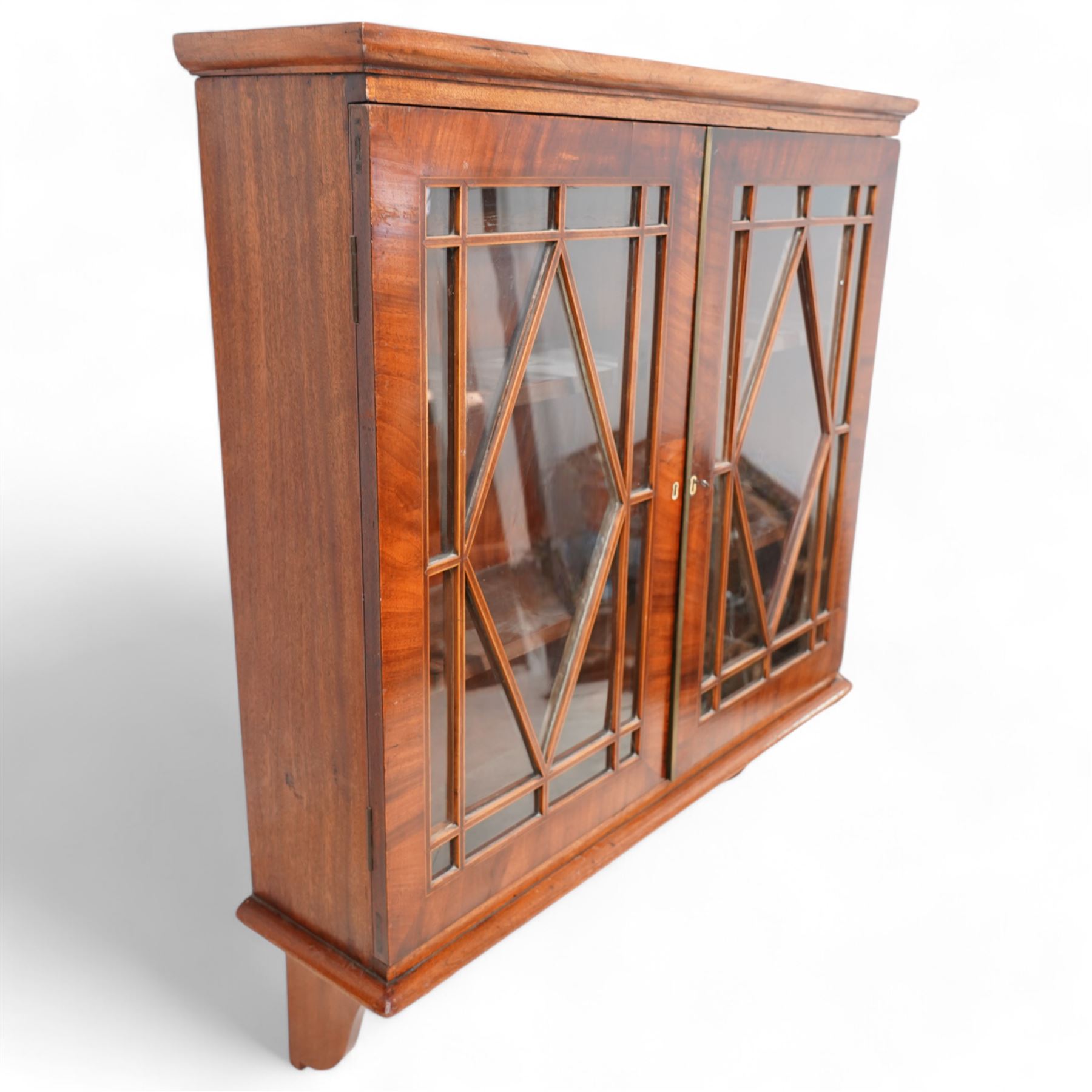 Edwardian inlaid mahogany wall-hanging cabinet, fitted with two astragal glazed doors enclosing two shelves, over shaped brackets