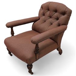 Late 19th century drawing room walnut framed open armchair, arched back over fluted and turned arm terminals and deep sprung seat, upholstered in buttoned maroon patterned fabric with stud detail on turned and fluted supports with castors