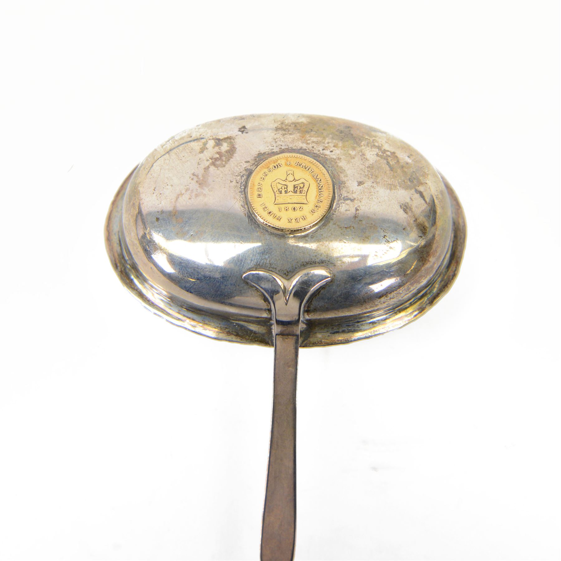 George III silver toddy ladle, the oval bowl set with a King George III 1802 gold one third of a guinea coin, with baleen twist handle, L40cm