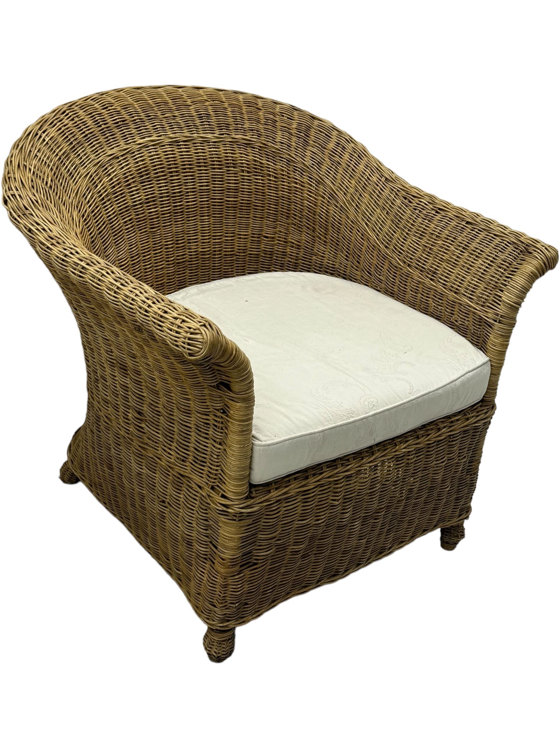 Rattan armchair and ottoman set, pair of armchairs featuring rounded backrests with wide armrests, woven wicker frame with weaving and upholstered seat cushions in off-white fabric with flowing floral pattern (W83 D80 H78cm); matching round ottoman with upholstered cushion on square wooden feet (W65 D65 H37cm)