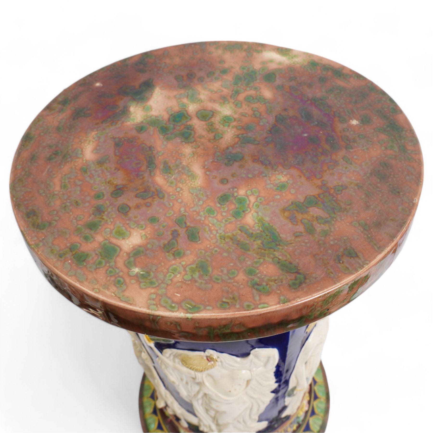 Late Victorian Copeland Majolica pedestal, circa 1850 - 1870, the cylindrical column moulded in relief with a frieze of Classical figures in cream on a cobalt glazed ground, the borders with coloured flower garlands and tortoiseshell mottled top, H62cm x D35cm