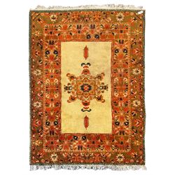 Moroccan amber ground thick pile rug, the plain ivory field decorated with a central pole medallion of star form, the wide guard bands decorated with repeating geometric and foliate patterns