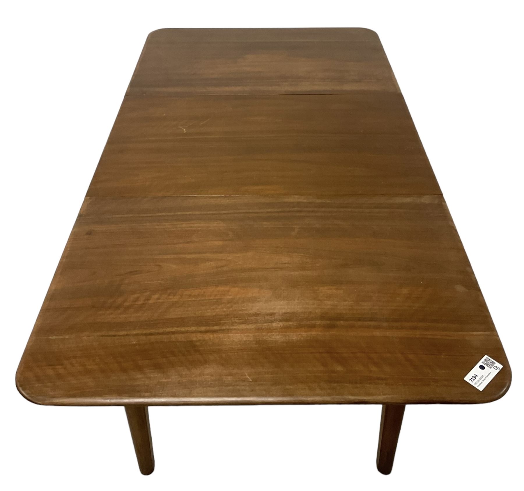 Mid-20th century teak extending dining table, rectangular top with rounded corners, raised on shaped tapering supports united by X-stretcher, with additional leaf