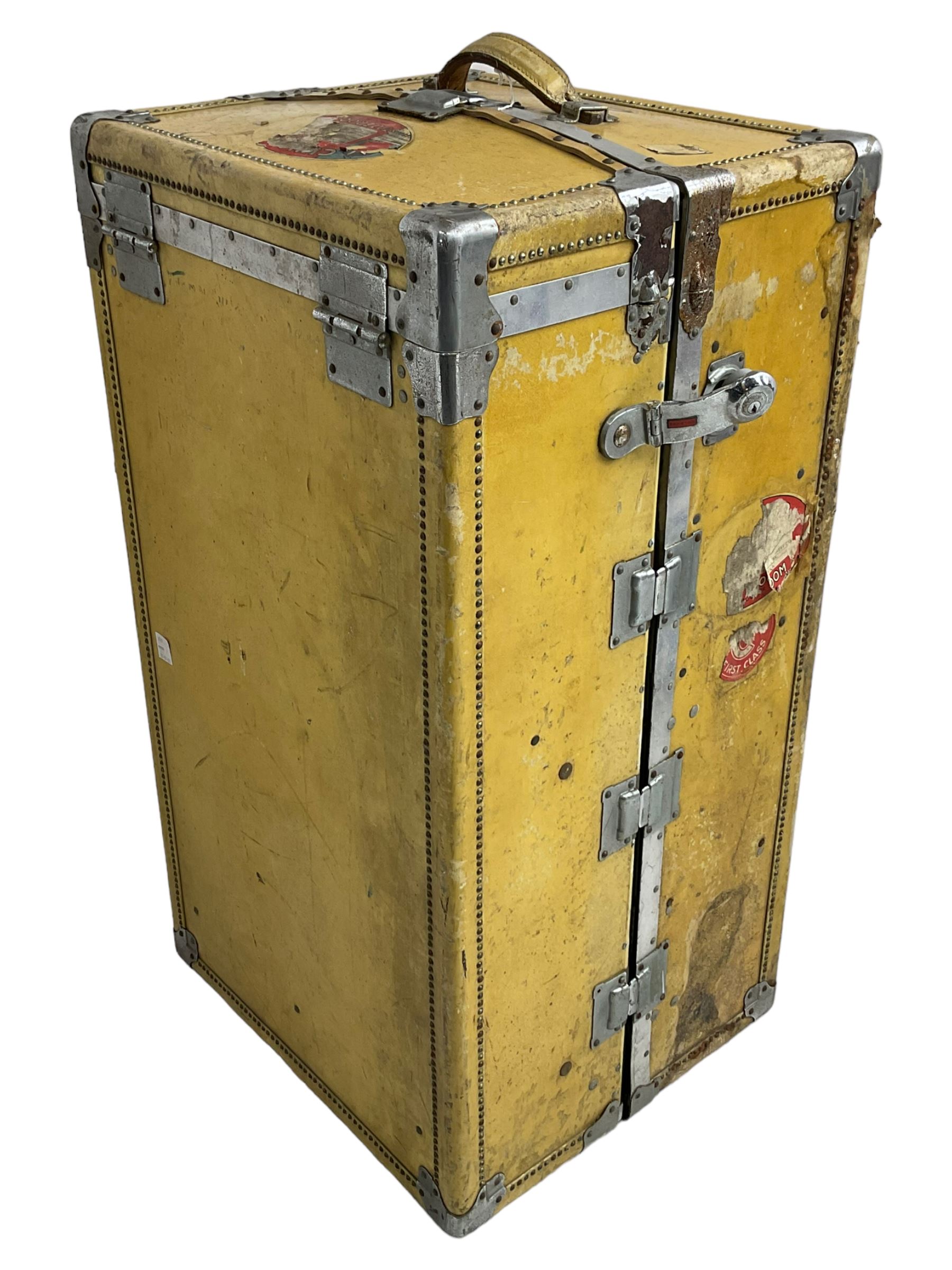 Early 20th century steamer traveling trunk, in yellow finish with chrome fixtures, the interior fitted with drawers and hangers, with various travel labels 