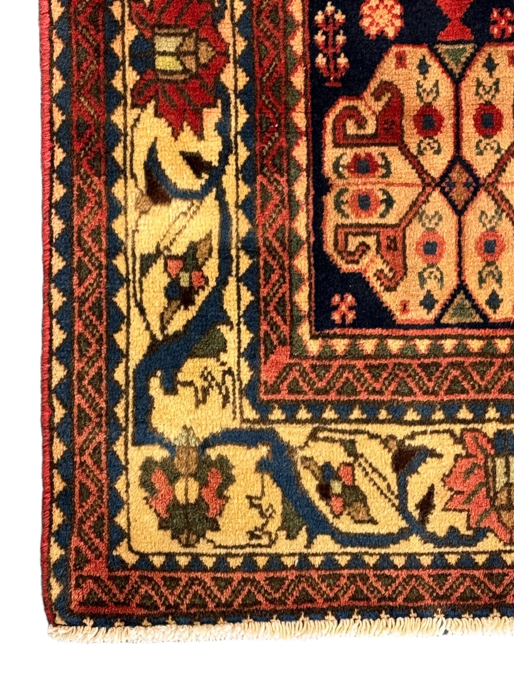 South West Persian Abadeh crimson ground rug, indigo ground with crimson lozenge field, decorated all over with small stylised motifs of flowerheads, hooks, animals and birds, guarded border decorated with trailing leaves and stylised plant motifs 