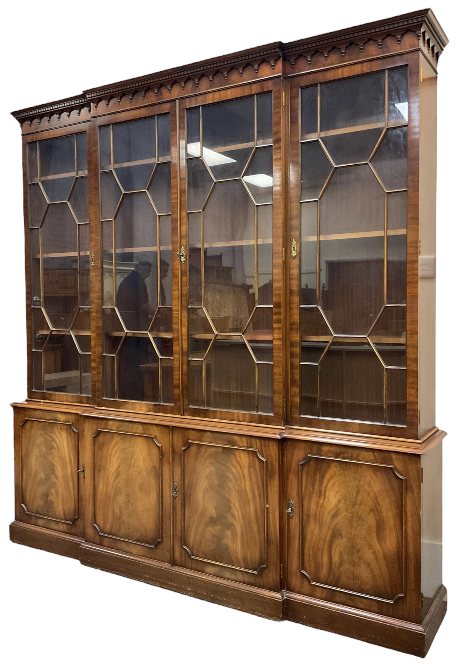 Bevan Funnell - Georgian design mahogany breakfront bookcase, moulded dentil and arcaded frieze over four astragal glazed doors, four cupboards below enclosed by figured doors, on skirted base