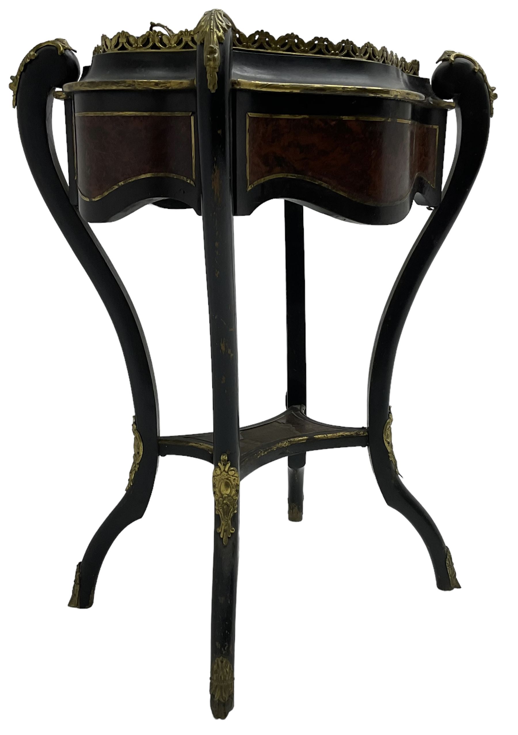 Late Victorian ebonised and amboyna wood jardinière planter, shaped form with removable lid inlaid with scrolling brass work and mounted by ornate cast gilt metal handles, the frieze rails inlaid with amboyna panels and brass stringing, on cabriole supports united by under-tier, decorated with cast gilt metal acanthus leaves and hooved feet caps