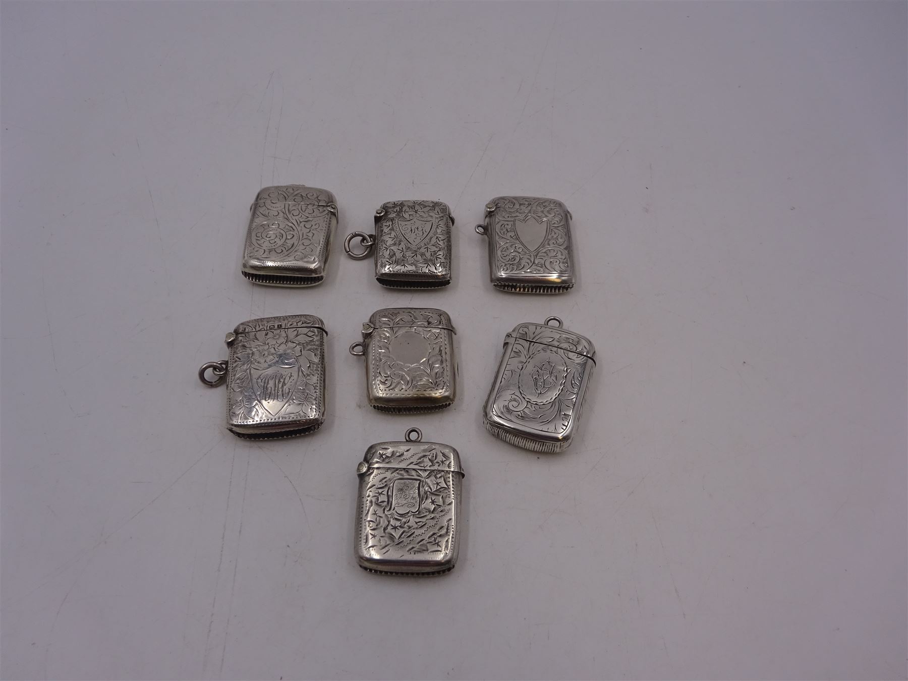 Seven early 20th century silver vesta cases, all of typical form, engraved with foliate and scrolling details, all hallmarked