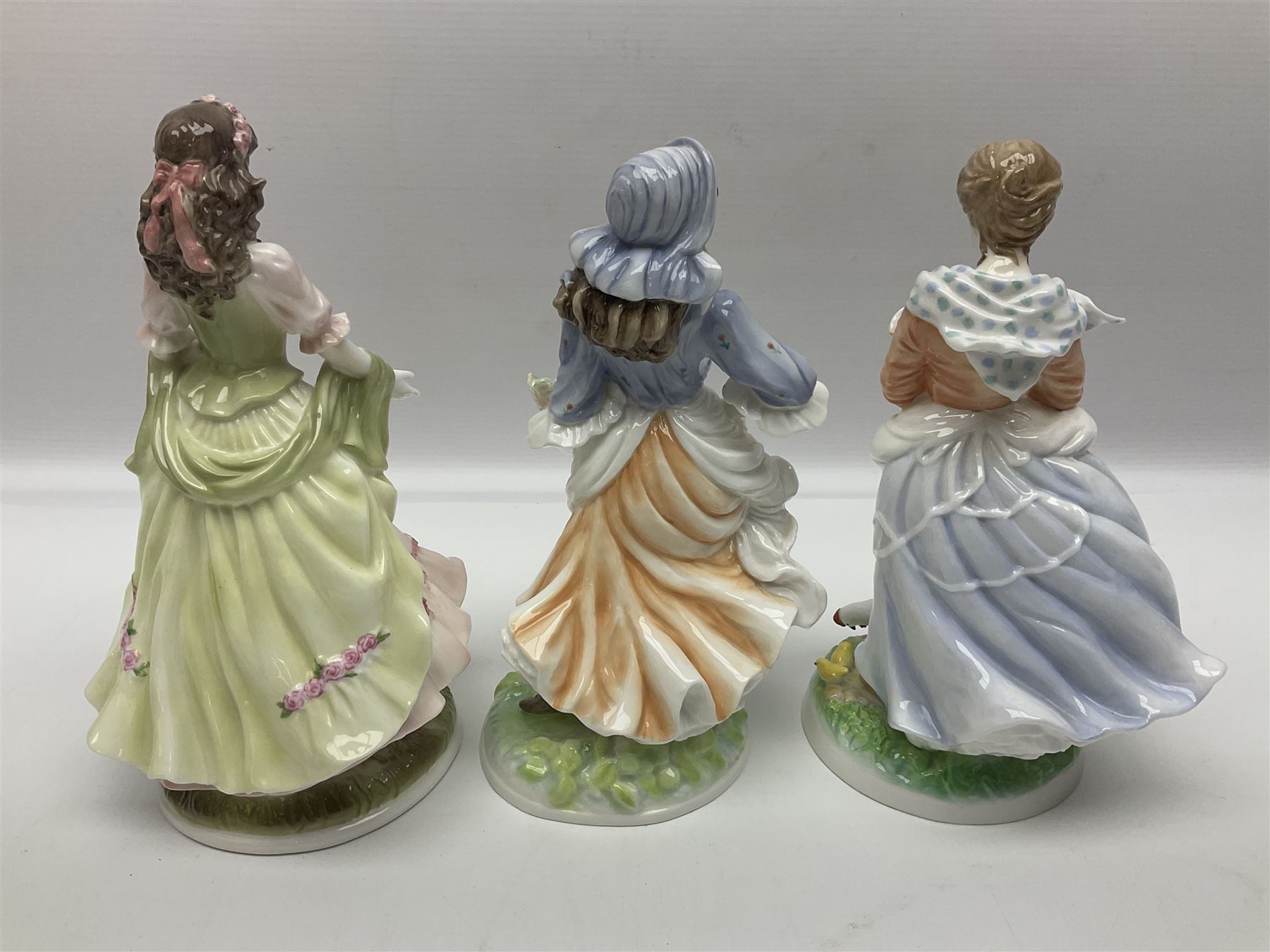 Five Royal Worcester figures, comprising The Queen of May, Rosie Picking Apples, A Farmers Wife, The Milkmaid and The Shepherdess, all with printed marks beneath and some with certificates of authentication   