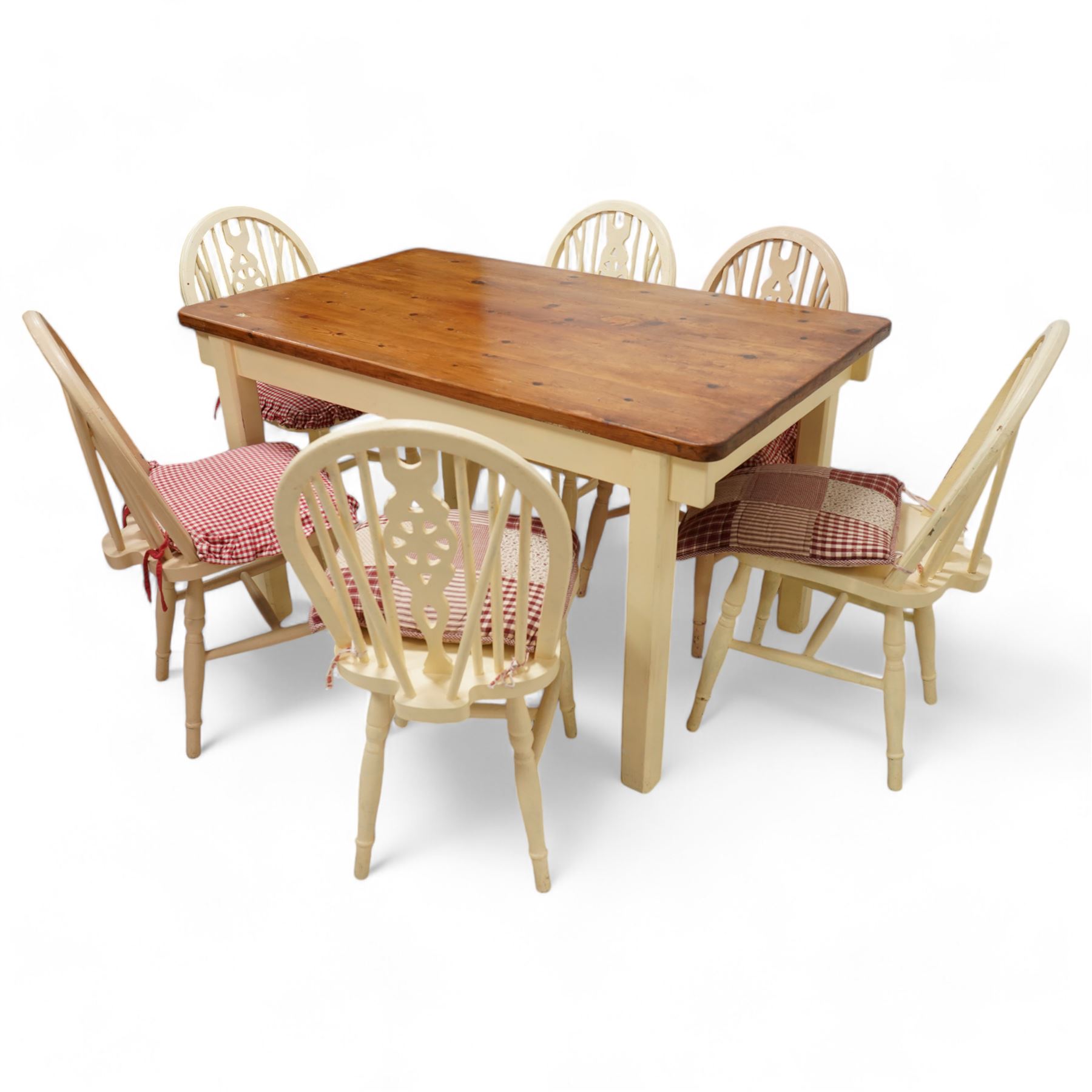 20th century pine kitchen dining table, stained top over cream painted base (W133cm D81cm H77cm); and six painted wheel-back chairs (H89cm)