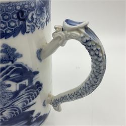 Two large 18th century Chinese blue and white tankards, each of cylindrical form, the first example with foliate mounted strap handle, the body painted with a shaped panel depicting a riverside landscape with pagodas and pine trees, against a textured ground decorated with floral sprays, H15cm D12cm, the second with serpent handle, the body painted with a similar riverside landscape, H14cm D12cm