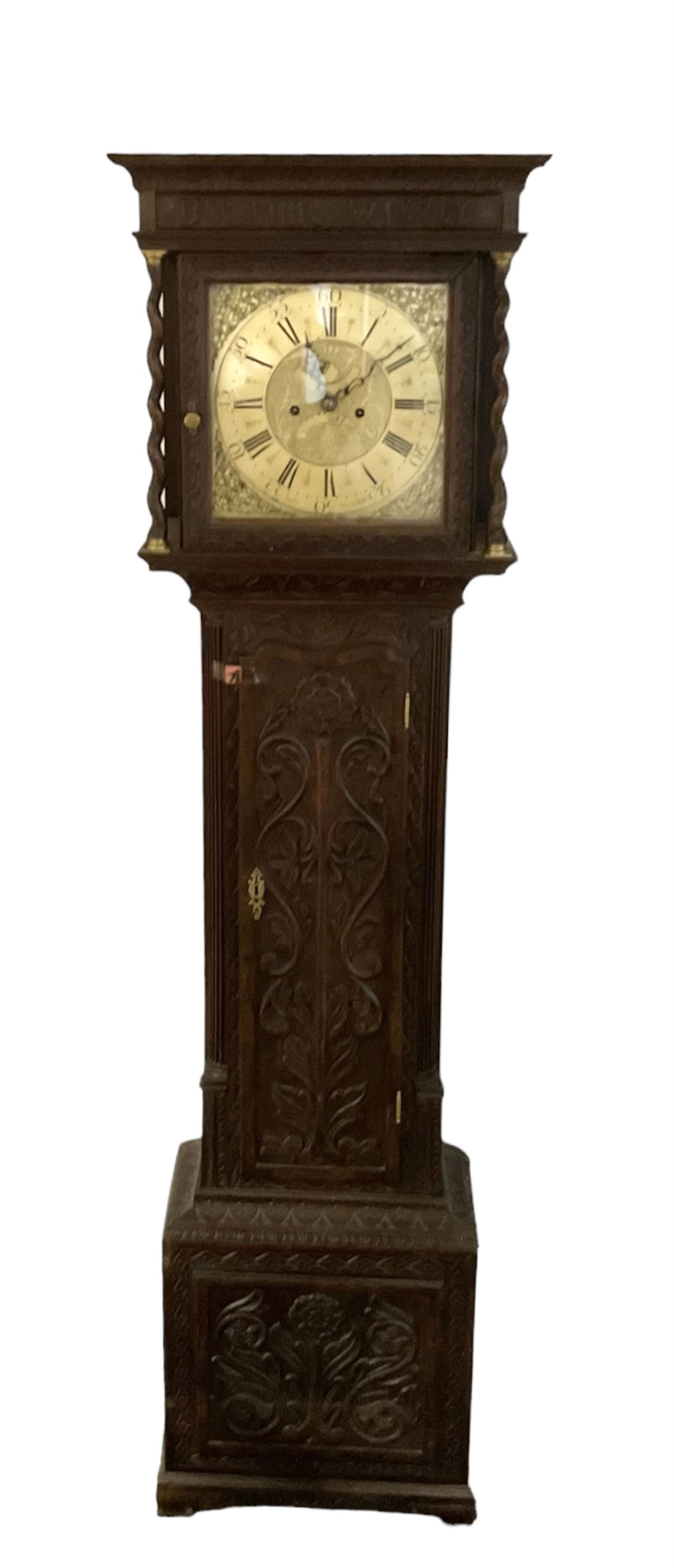 8-day - profusely carved oak longcase, with a flat top and square hood door beneath, door flanked by barley twist columns with brass capitals, trunk with reeded quarter columns and wavy topped door, on a carved plinth raised on bracket feet, brass dial with an engraved and matted dial centre, penny moon and date aperture, chapter ring inscribed “John Stancliffe” with Roman numerals and five-minute Arabic's, rack striking movement with a recoil anchor escapement. With pendulum and weights.