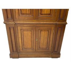 George III and later oak and mahogany banded corner cupboard, moulded cornice over four panelled doors, the door panels inlaid with mahogany bands, projecting square pilasters throughout with applied reeded mouldings, the painted interior fitted with shaped shelves, on moulded plinth base 