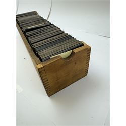 Collection of magic lantern slides, predominantly depicting views of India, with scenes including including the Taj Mahal, tombs, monuments, street scenes, people and animals, in compartmentalised wooden case 