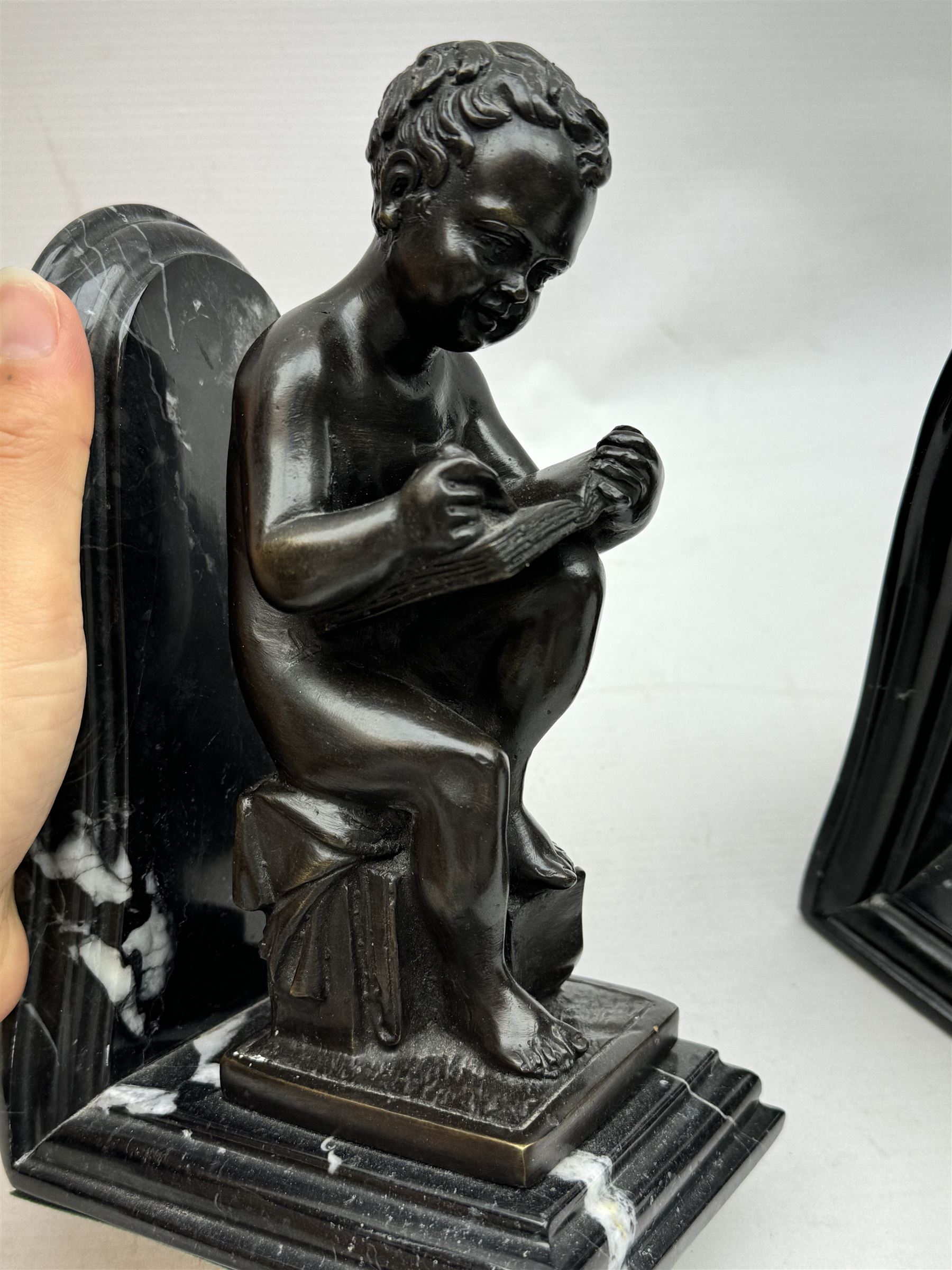 Pair of marble and bronzed bookends, modelled as putti reading, H22cm